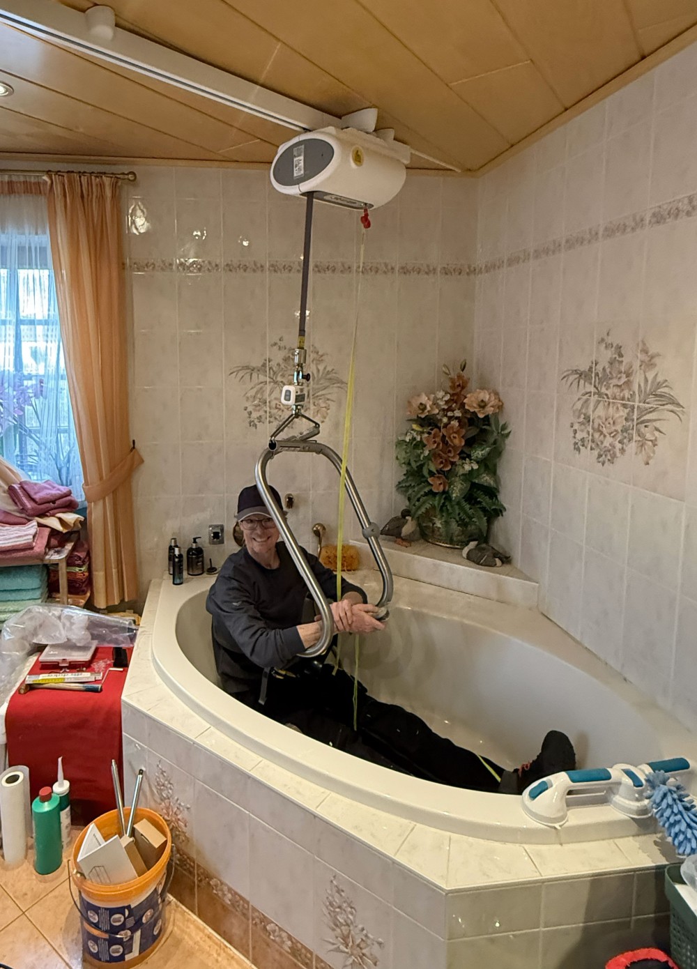 Unser Berater sitzt mit dem Hebebügel in der Badewanne