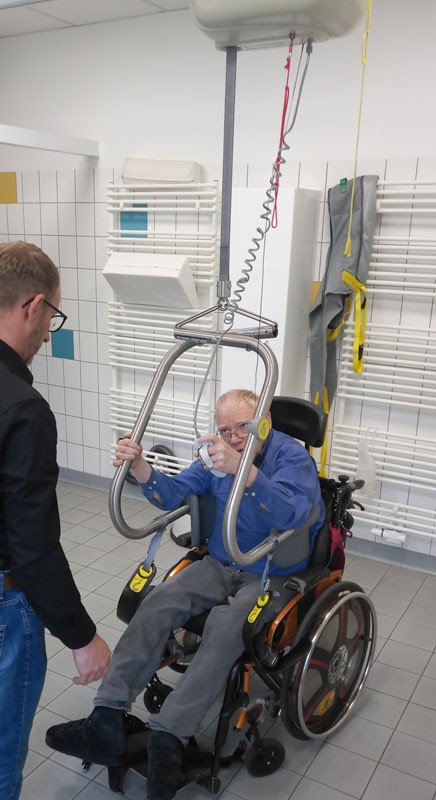 Jürgen Pohl im Rollstuhl beim Anlegen des Hebebügels